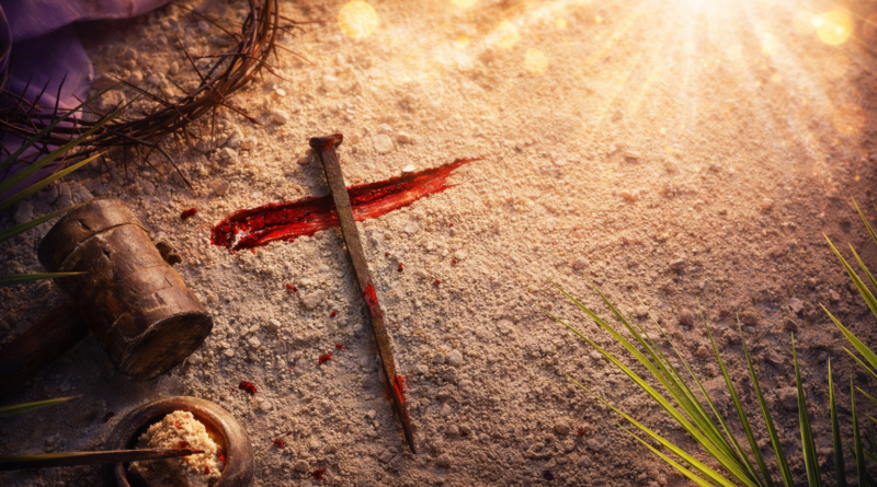 Pregos ensanguentados formando uma cruz sobre a areia com coroa de espinhos, martelo e luz divina, simbolizando o sacrifício de Jesus Cristo e a redenção.